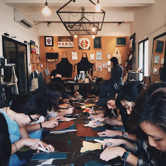 Corporate_team_building_leathercraft_workshop_in_Singapore_with_employees_collaborating_on_handmade_leather_items
